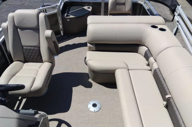 Slide: The Image of 2025 Sun Tracker Fishin' Barge 20 DLX interior with beige seating and cup holders. - 9