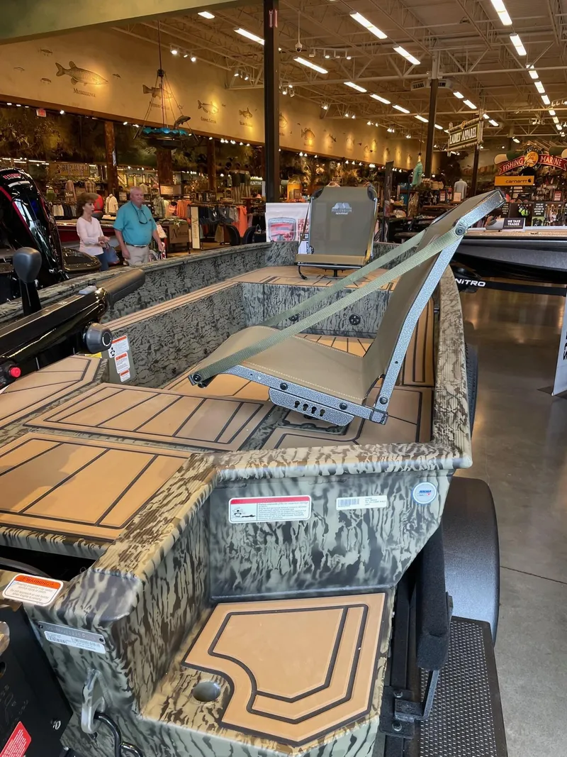 Slide: The Image of 2025 Tracker Grizzly 1650 T Prairie Wings Edition boat displayed in a showroom. - 3