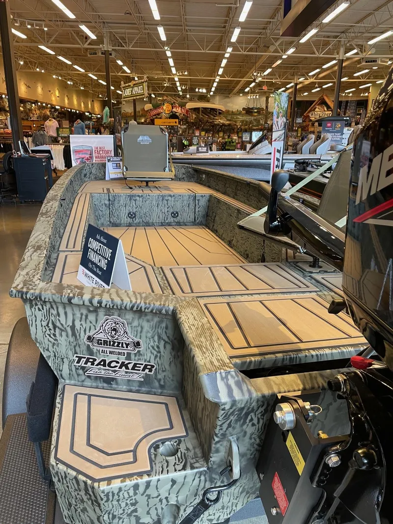 Slide: The Image of 2025 Tracker Grizzly 1650 T Prairie Wings Edition boat displayed in a showroom. - 4