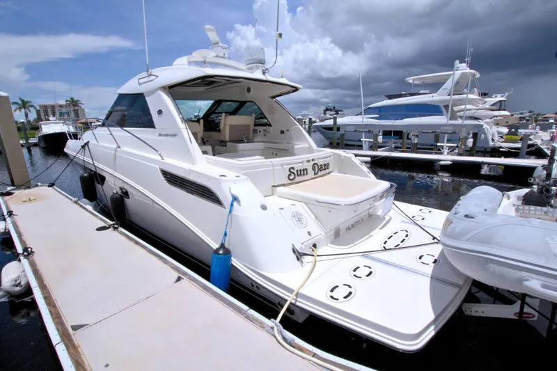 Slide: The Image of 2013 Sea Ray 450 Sundancer yacht docked at marina under cloudy sky. - 10