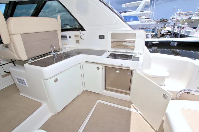 Slide: The Image of Luxurious 2013 Sea Ray 450 Sundancer yacht interior with kitchenette and seating area. - 20