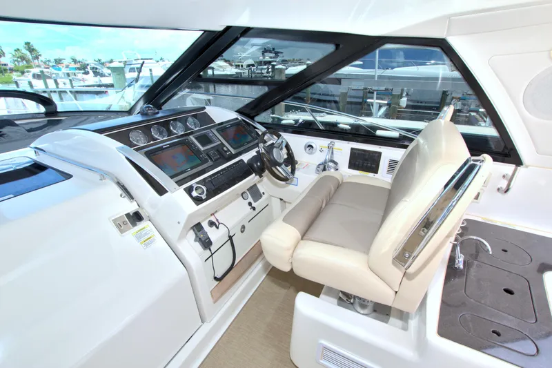 Slide: The Image of Helm of 2013 Sea Ray 450 Sundancer with modern controls and comfortable seating. - 24
