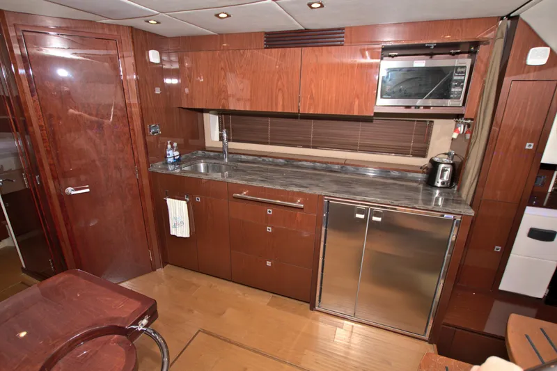 Slide: The Image of Luxurious kitchen interior of 2013 Sea Ray 450 Sundancer yacht with wood cabinetry and modern appliances. - 28