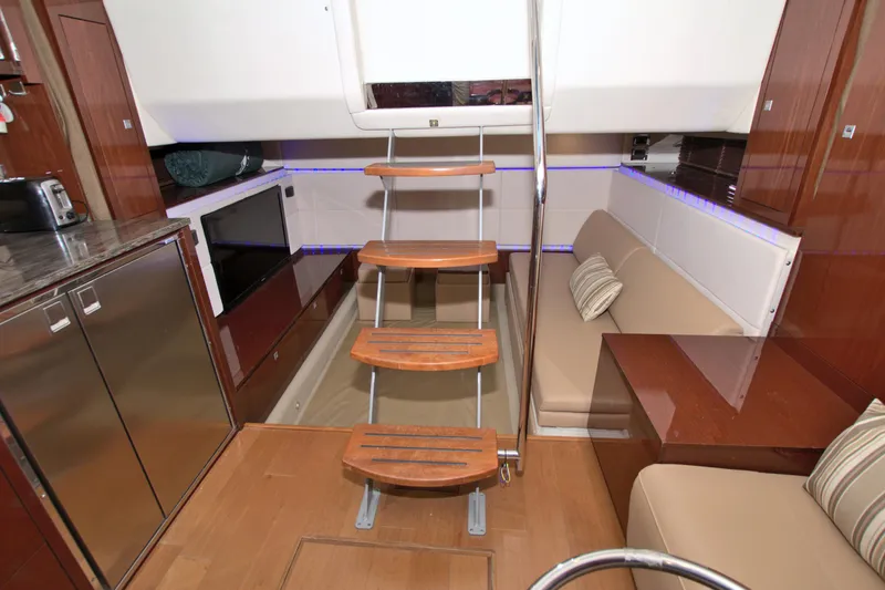 Slide: The Image of Interior of 2013 Sea Ray 450 Sundancer yacht with modern kitchen and seating area. - 42