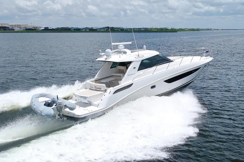 Slide: The Image of 2013 Sea Ray 450 Sundancer cruising on open water, creating a wake behind. - 5