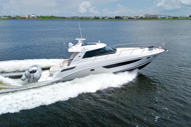 Slide: The Image of 2013 Sea Ray 450 Sundancer cruising on a calm lake under a partly cloudy sky. - 6
