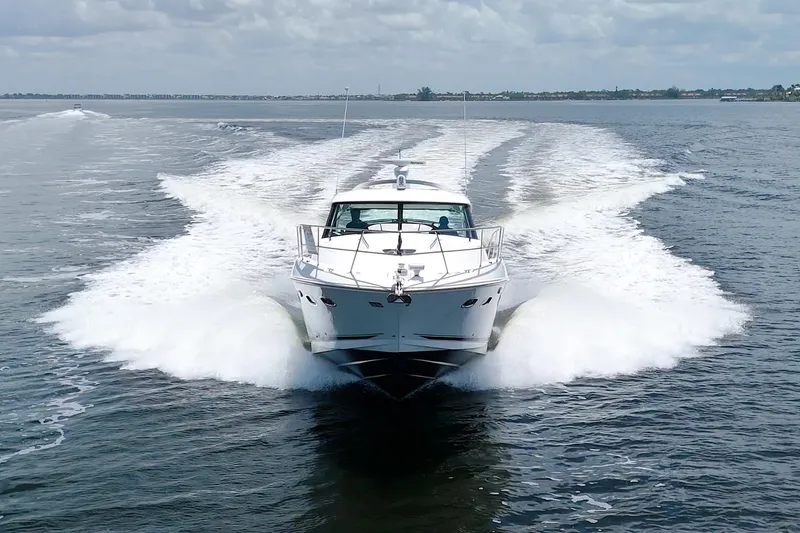 Slide: The Image of 2013 Sea Ray 450 Sundancer cruising on open water, creating a dynamic wake. - 7