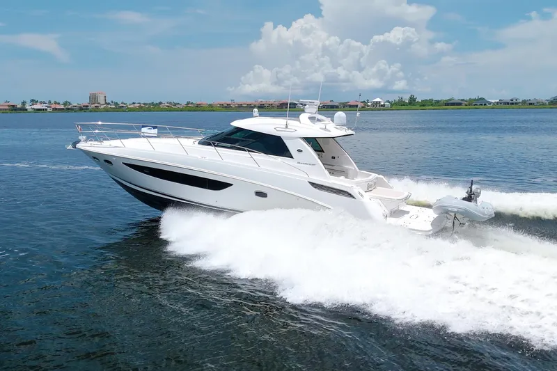Slide: The Image of 2013 Sea Ray 450 Sundancer cruising on a sunny day, creating waves. - 9