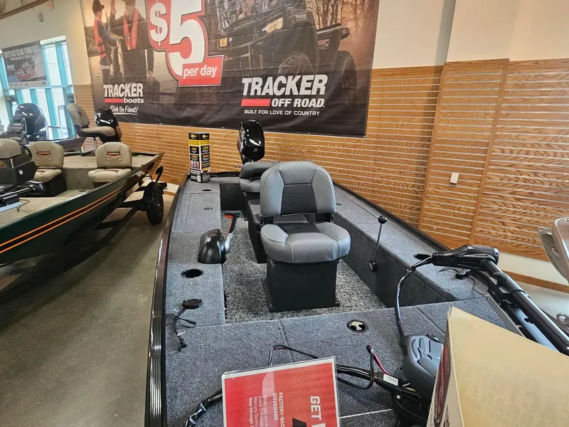 Slide: The Image of 2025 Tracker Panfish 17 boat displayed in showroom with promotional banner. - 2