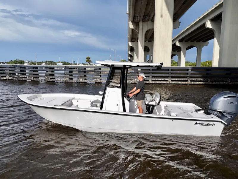 Slide: The Image of 2025 Action Craft 24 Coastal Bay boat cruising under a bridge on a sunny day. - 13