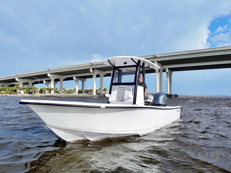 Slide: The Image of 2025 Action Craft 24 Coastal Bay boat cruising under a bridge on a sunny day. - 21