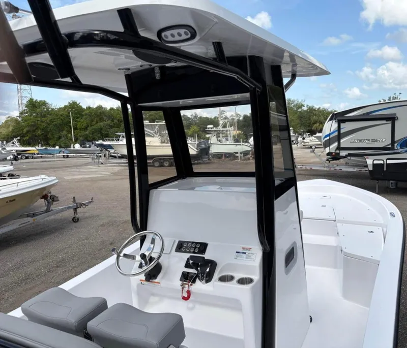 Slide: The Image of 2025 Action Craft 24 Coastal Bay boat with modern console and seating, docked outdoors. - 29