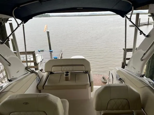 Slide: The Image of 2020 Regal 26 XO boat interior with seating, overlooking a calm waterfront. - 13