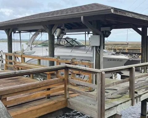 Slide: The Image of 2020 Regal 26 XO boat docked under a wooden shelter by the water. - 15