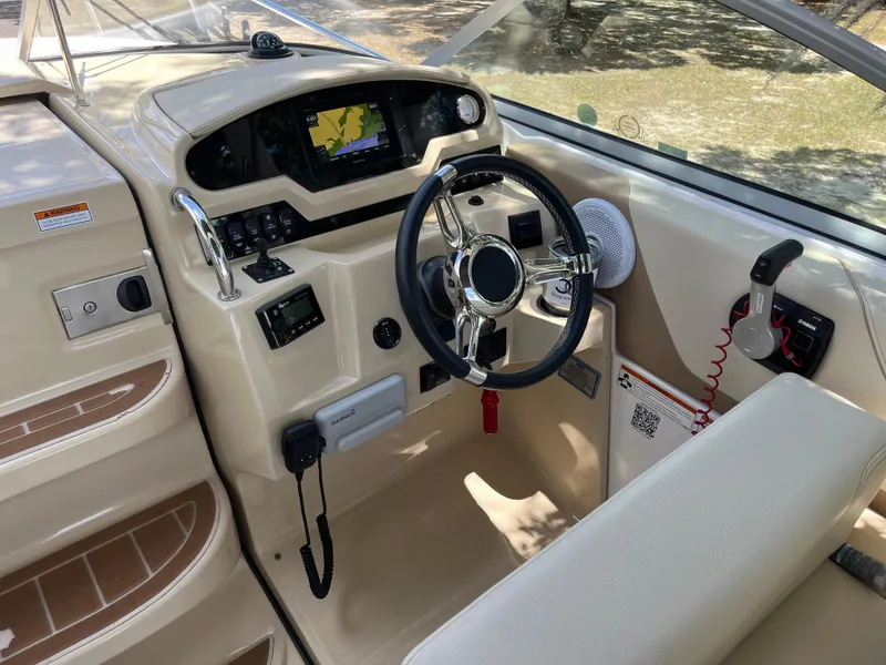 Slide: The Image of 2020 Regal 26 XO boat cockpit with steering wheel, navigation system, and control panel. - 19