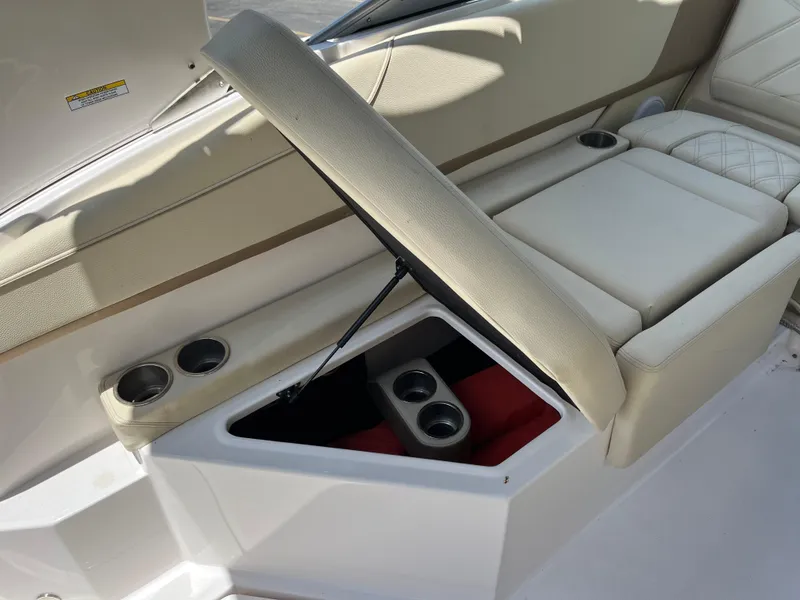 Slide: The Image of 2020 Regal 26 XO boat interior with open storage compartment and cup holders. - 24
