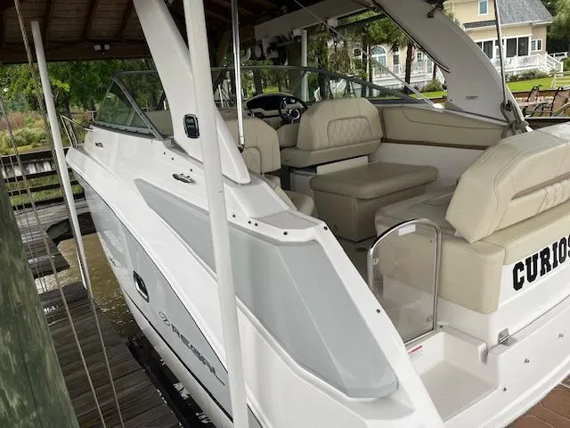 Slide: The Image of 2020 Regal 26 XO boat with beige interior, docked under a wooden shelter. - 3