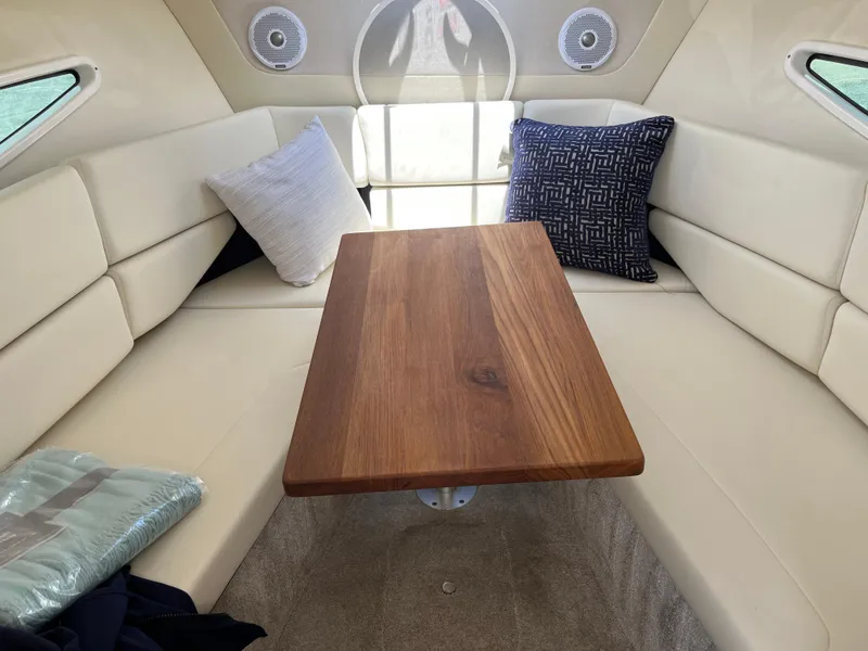 Slide: The Image of Interior of 2020 Regal 26 XO boat with wooden table and cushioned seating. - 31