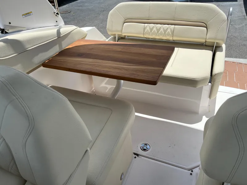 Slide: The Image of Luxurious seating area on a 2020 Regal 26 XO boat with wooden table. - 32