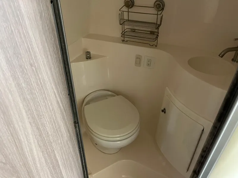 Slide: The Image of 2020 Regal 26 XO boat bathroom with toilet, sink, and storage cabinet. - 37