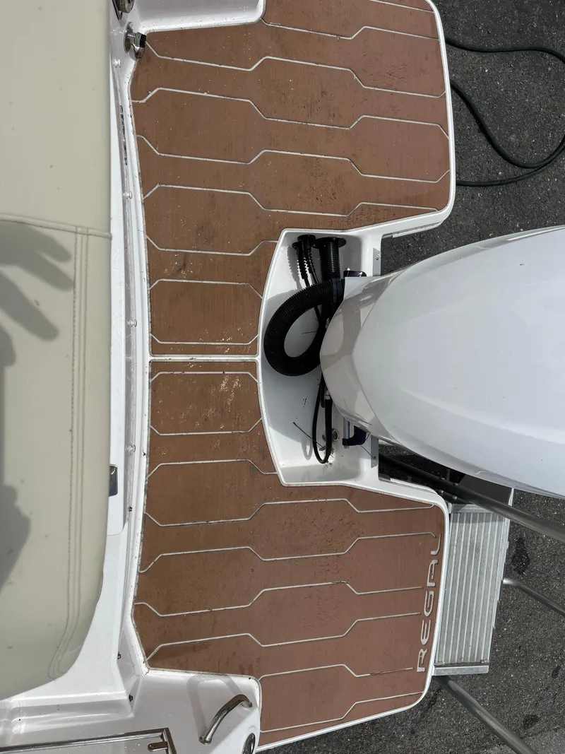 Slide: The Image of 2020 Regal 26 XO boat deck with outboard motor, featuring teak-style flooring. - 38
