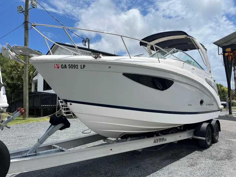 Slide: The Image of 2020 Regal 26 XO boat on trailer, parked outdoors under a partly cloudy sky. - 47