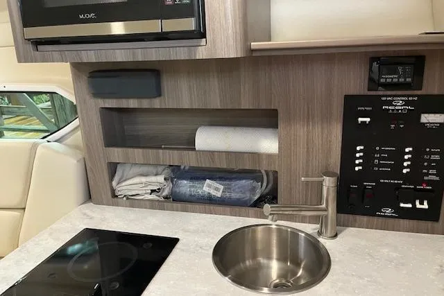 Slide: The Image of 2020 Regal 26 XO boat interior with sink, control panel, and storage shelves. - 9