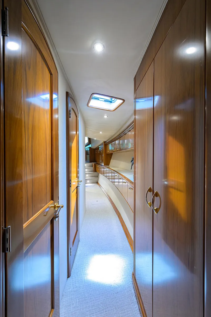 Slide: The Image of Luxurious hallway inside 2004 Sea Force IX 82 Enclosed Bridge yacht, featuring elegant wood paneling. - 29