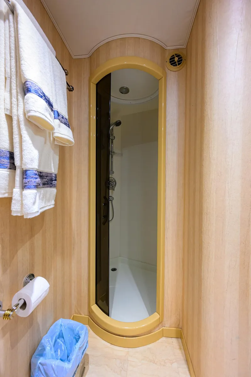 Slide: The Image of Shower area in 2004 Sea Force IX 82 Enclosed Bridge yacht, featuring wooden paneling and towels. - 45