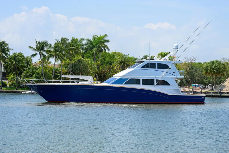 Slide: The Image of Luxury 2004 Sea Force IX 82 Enclosed Bridge yacht on calm water, surrounded by palm trees. - 5