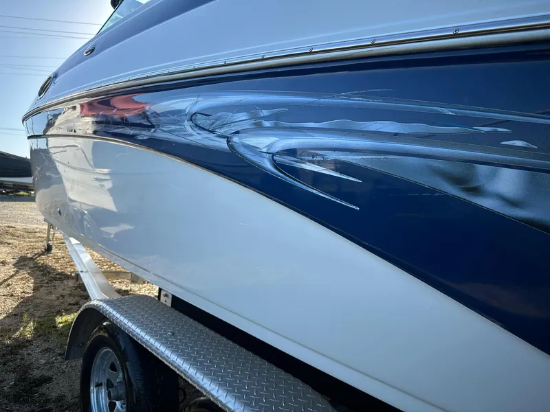 Slide: The Image of 2006 Crownline 270 BR boat with blue and white exterior on a trailer. - 15