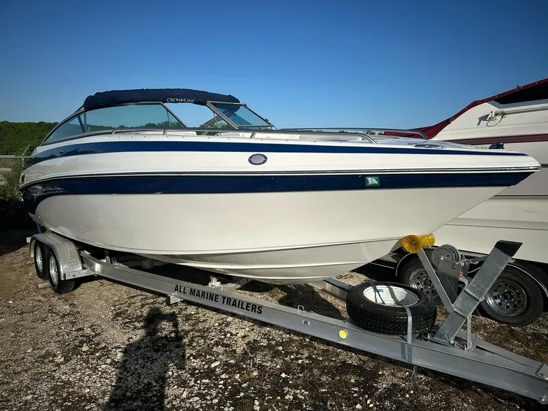 Slide: The Image of 2006 Crownline 270 BR boat on trailer, white with blue accents, parked outdoors. - 17