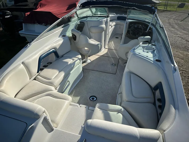 Slide: The Image of 2006 Crownline 270 BR boat interior with white seating and steering console. - 2