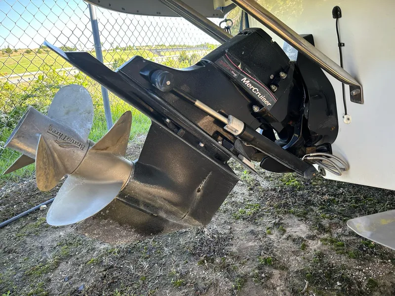 Slide: The Image of 2006 Crownline 270 BR boat with MerCruiser outdrive and propeller, parked on grass. - 6