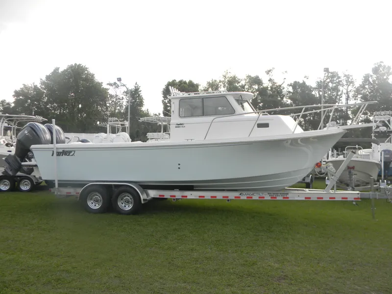 The Image of 2025 Parker 2820 XLD Sport Cabin boat on trailer, parked on grass. - 0