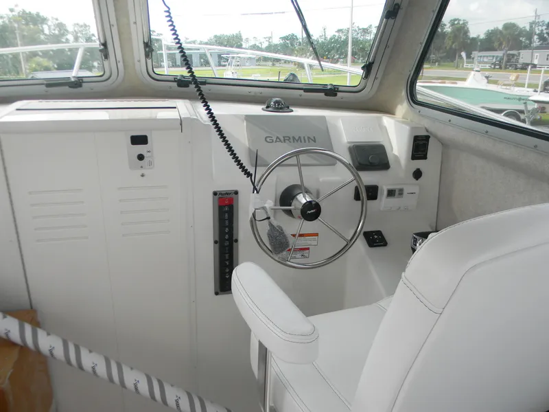 Slide: The Image of 2025 Parker 2820 XLD Sport Cabin helm with Garmin navigation system and white captain's chair. - 3
