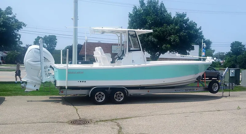 Slide: The Image of 2023 Regulator 26XO boat on trailer, parked outdoors, side view. - 0