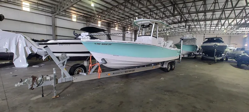 Slide: The Image of 2023 Regulator 26XO boat in storage, on a trailer, in a large warehouse. - 1