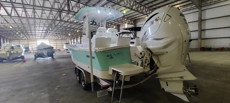 Slide: The Image of 2023 Regulator 26XO boat in warehouse, featuring a powerful outboard motor. - 10