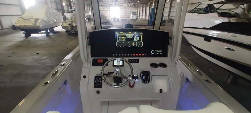 Slide: The Image of 2023 Regulator 26XO boat dashboard with modern controls in a storage facility. - 12