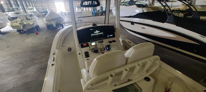 Slide: The Image of 2023 Regulator 26XO boat interior in a storage facility, showcasing helm and seating. - 14