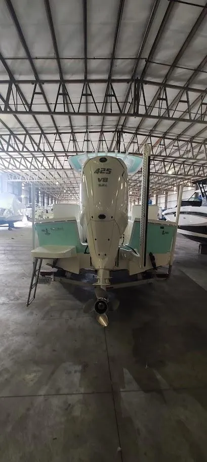 Slide: The Image of 2023 Regulator 26XO boat in storage, rear view with powerful outboard motor. - 16