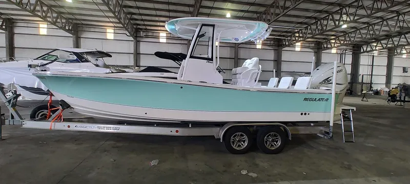 Slide: The Image of 2023 Regulator 26XO boat on trailer in warehouse setting. - 2