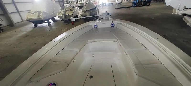 Slide: The Image of 2023 Regulator 26XO boat interior in a storage facility, showcasing spacious seating and deck layout. - 35