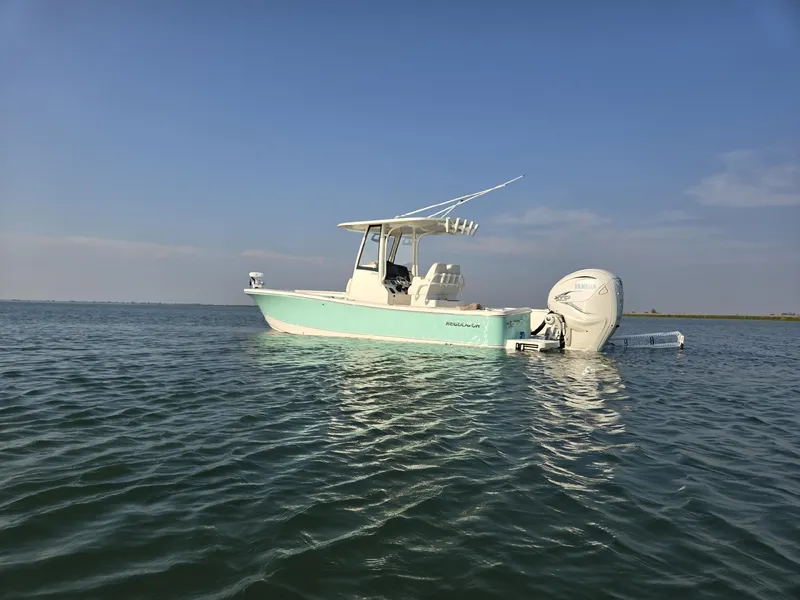 Slide: The Image of 2023 Regulator 26XO boat on calm water under clear blue sky. - 4