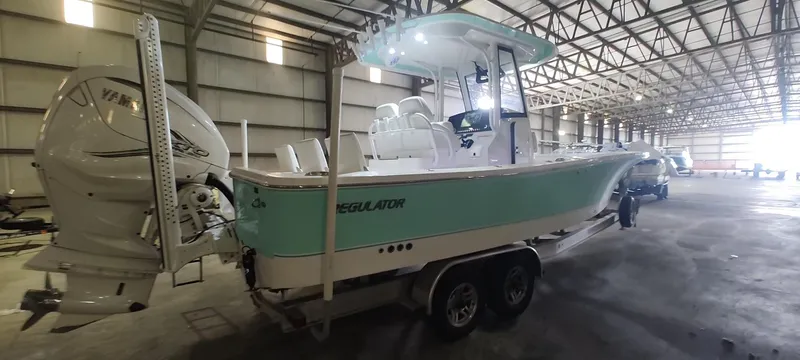 Slide: The Image of 2023 Regulator 26XO boat in warehouse, featuring dual engines and sleek design. - 7