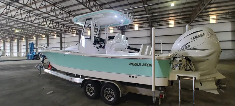 Slide: The Image of 2023 Regulator 26XO boat in warehouse, featuring Yamaha outboard engine. - 9