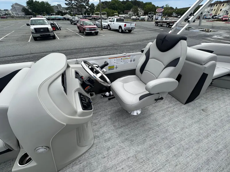 Slide: The Image of Captain's seat and helm of 2025 Berkshire 22RFX LE 2.75 pontoon boat in parking lot. - 12
