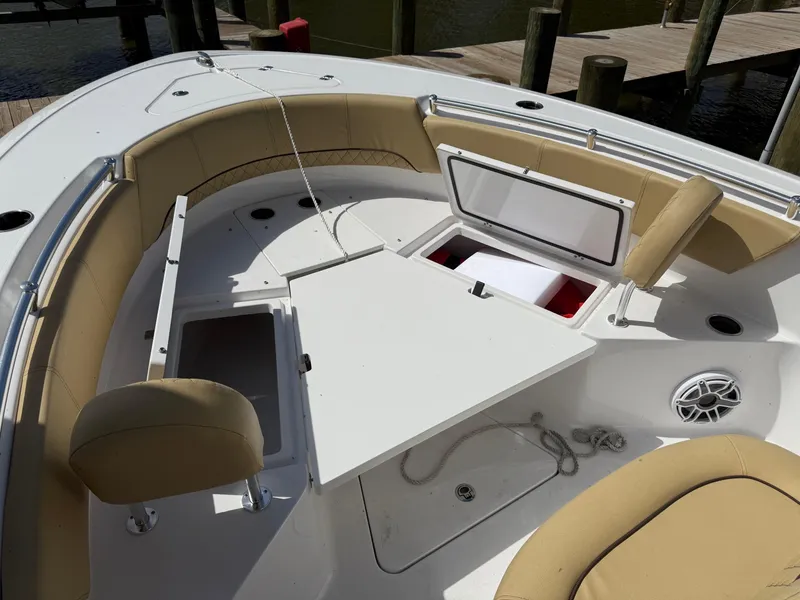 Slide: The Image of 2023 Sportsman Open 232 Center Console boat with tan seating and open storage compartments. - 16