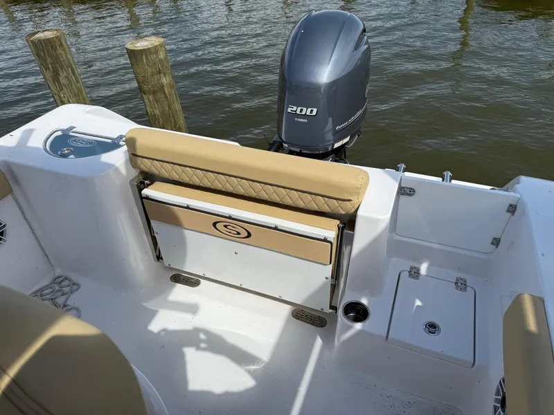 Slide: The Image of 2023 Sportsman Open 232 Center Console boat with Yamaha 200 engine, docked by wooden posts. - 6